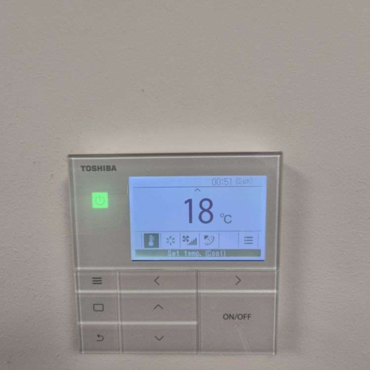 Toshiba digital wall-mounted air conditioning controller set to 18 degrees cooling mode
